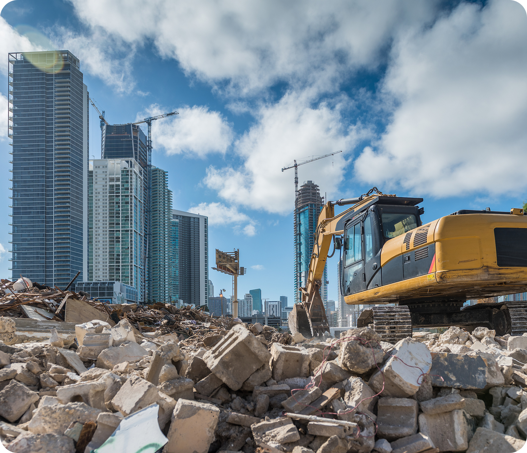 Construction site with excavator and skyscrapers.