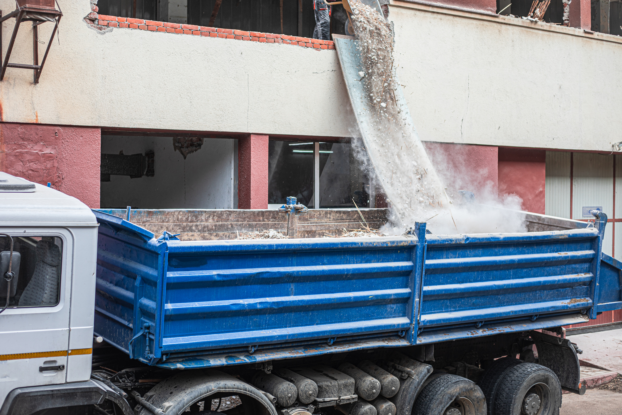 Debris being dumped into a blue truck.