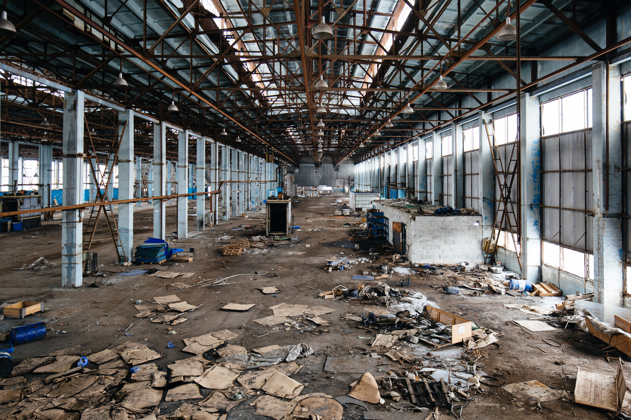 Abandoned warehouse interior with scattered debris.
