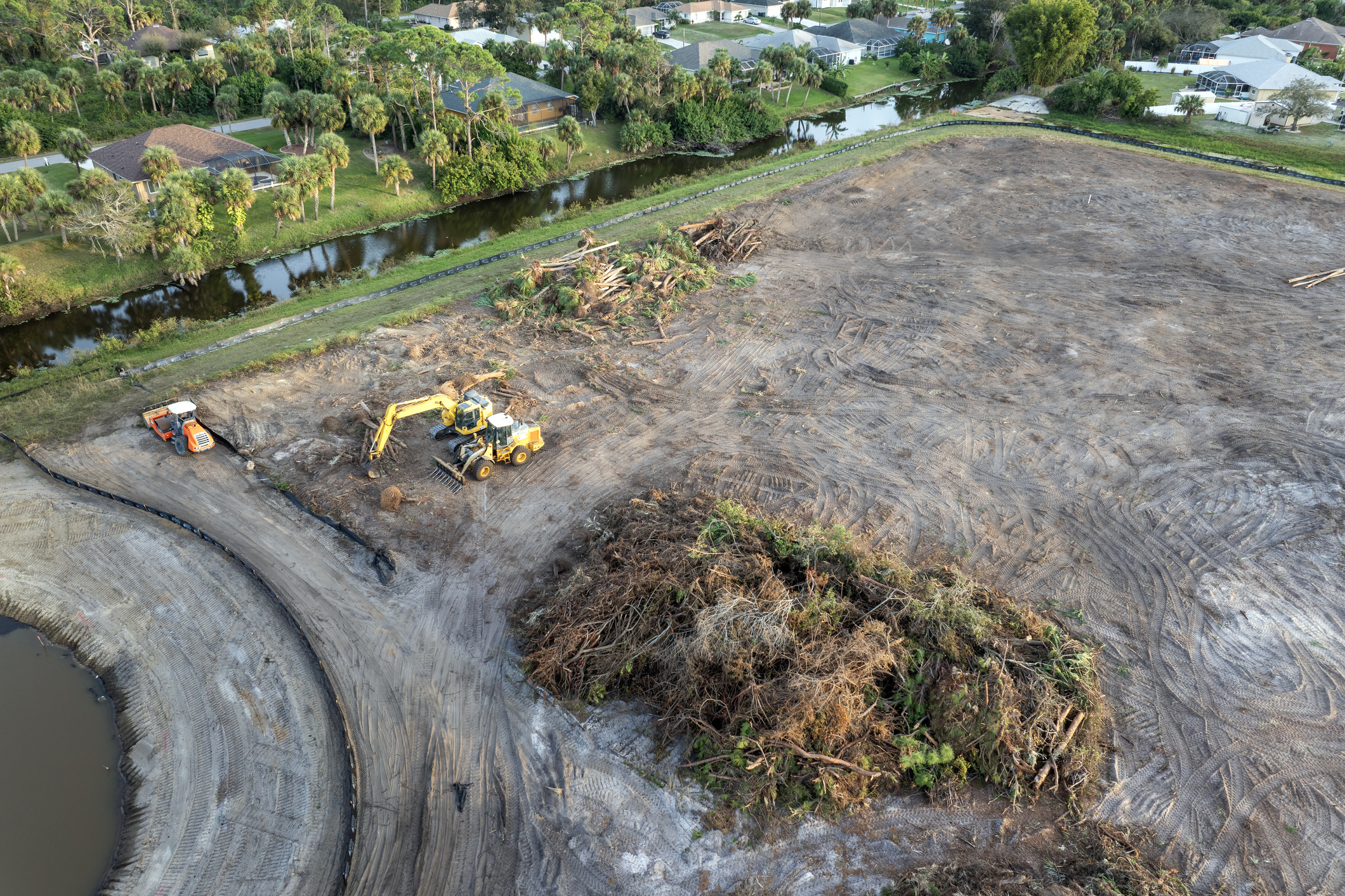 Land clearing with construction equipment and debris.