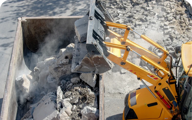 Excavator loading debris into a container.