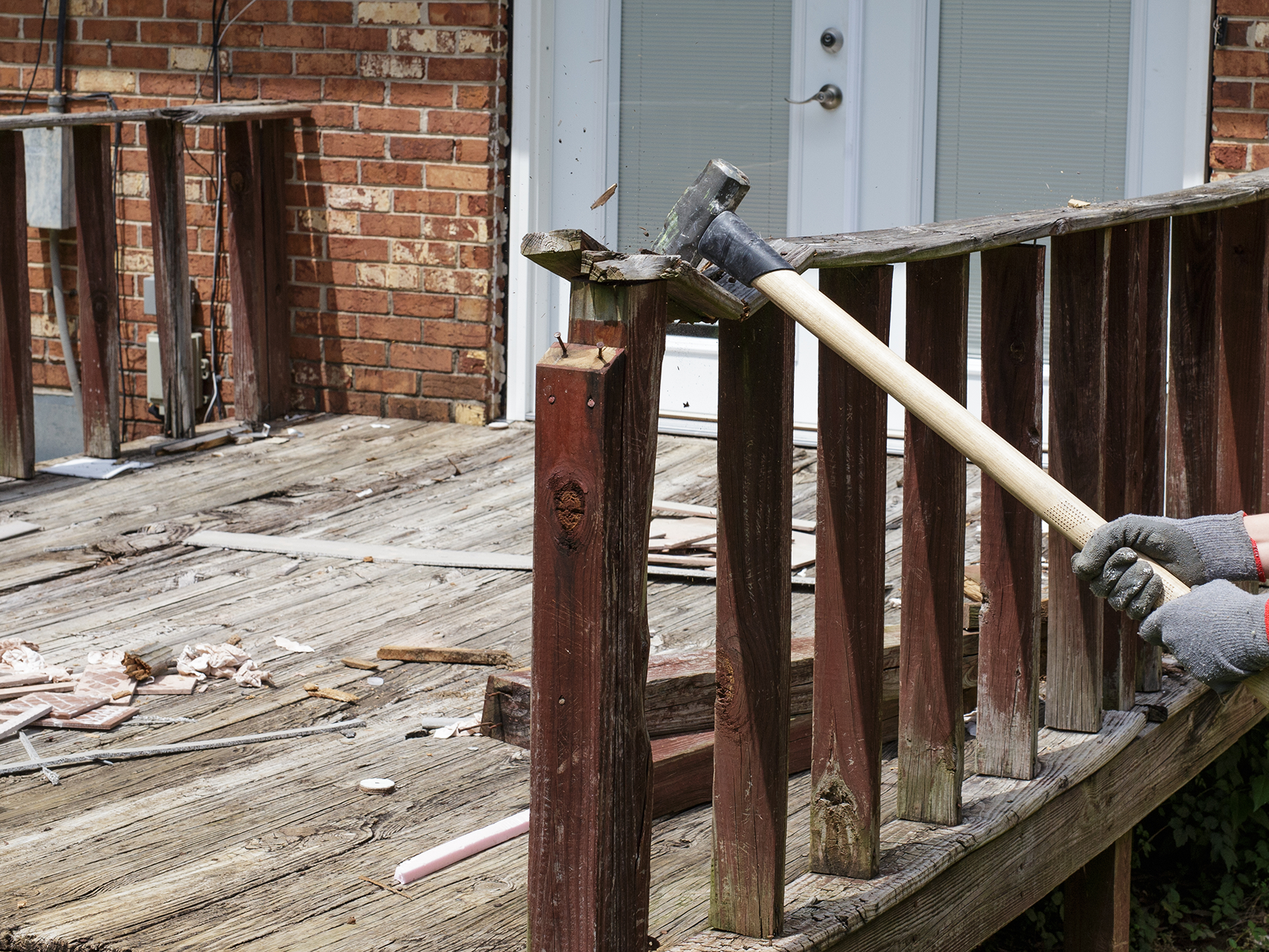 Demolition of wooden deck with sledgehammer.